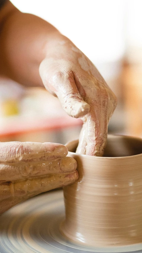 someone is working on some pottery on a table