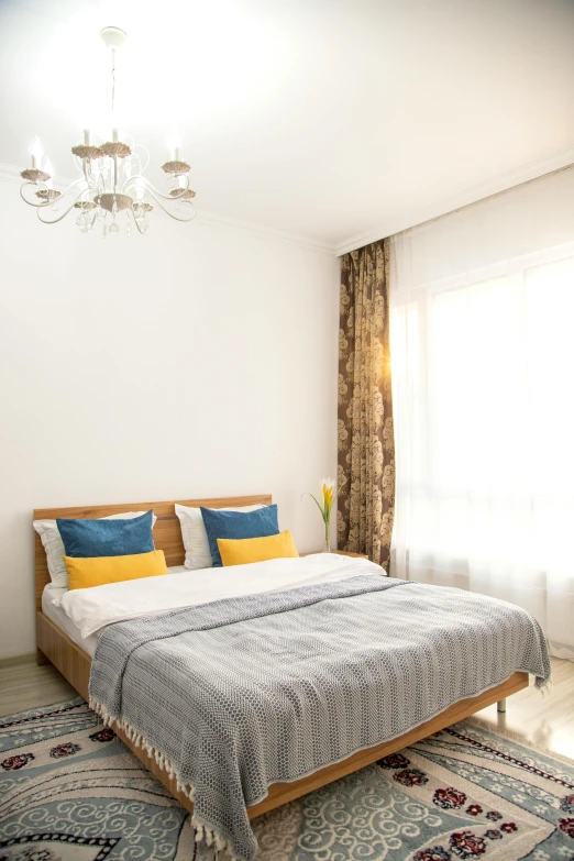 a bed sitting in front of a window with a white head board