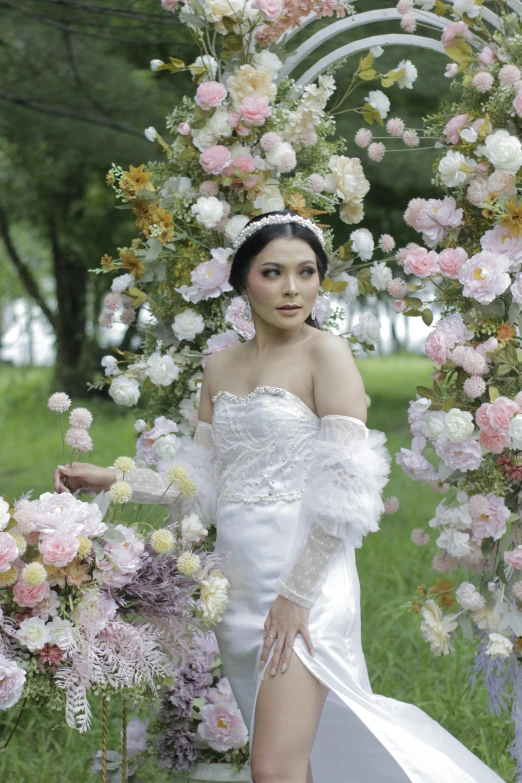 a  is wearing a wedding dress with long sleeves and flower decorations