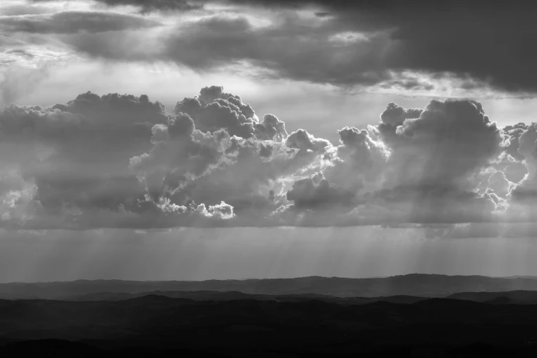 sun rays filtering through clouds on top of mountains