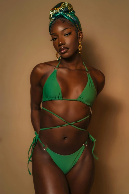 a black woman wearing a bikini top and a green head wrap