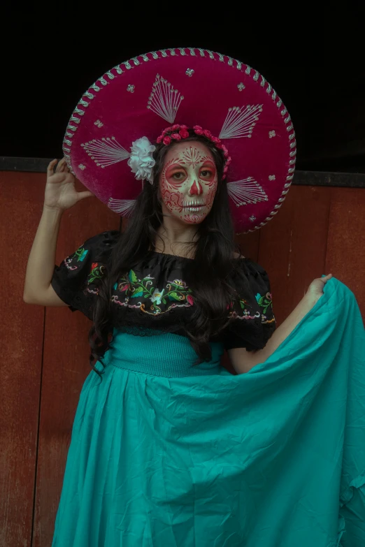 a woman dressed in makeup wearing a pink mexican hat