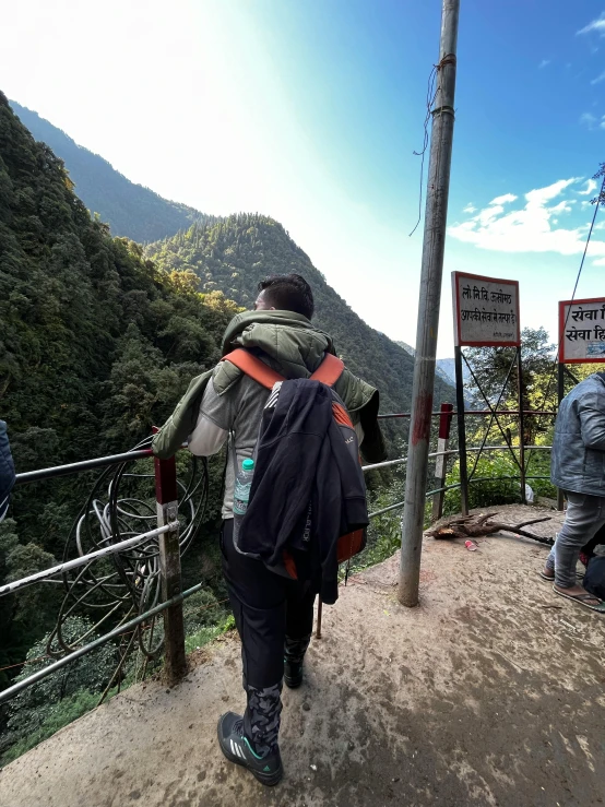 a person carrying a bag is on a dirt road