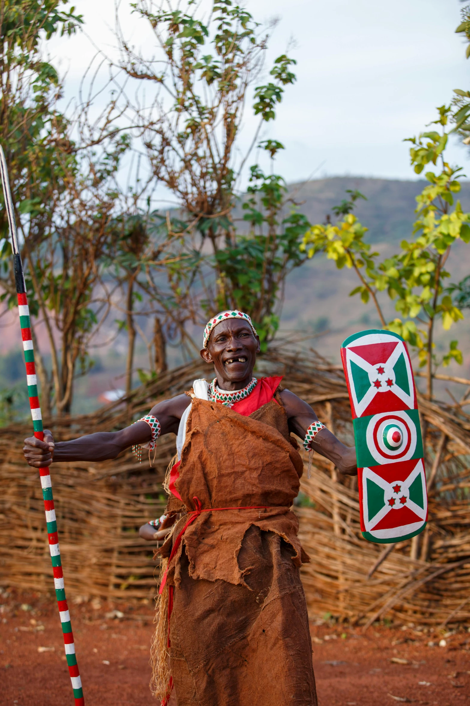 a native indian man dressed in brown holding a stick