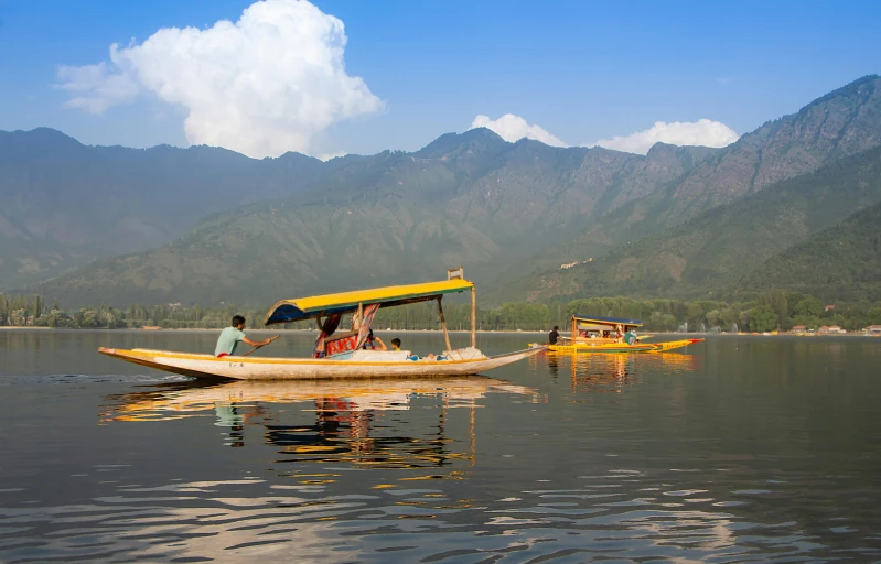 two people on a yellow boat in the water