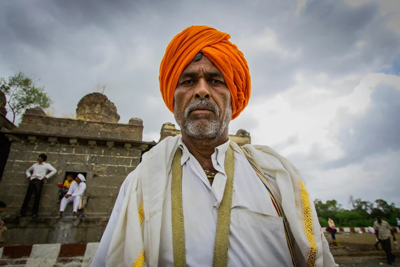 an indian man is dressed in orange