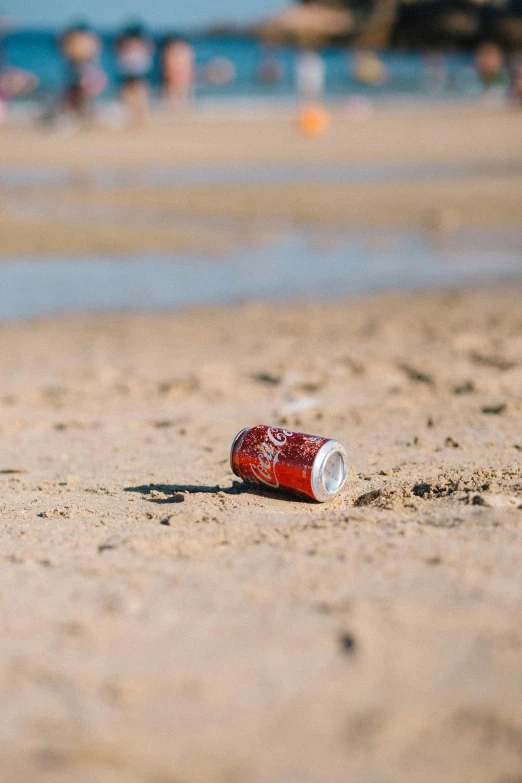 there is a bottle that is lying in the sand