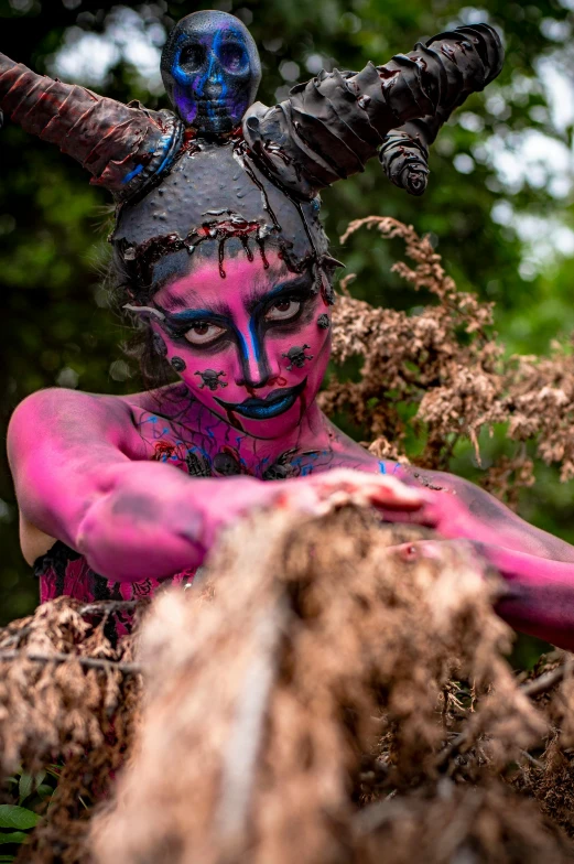 the woman is covered in pink and blue body paint