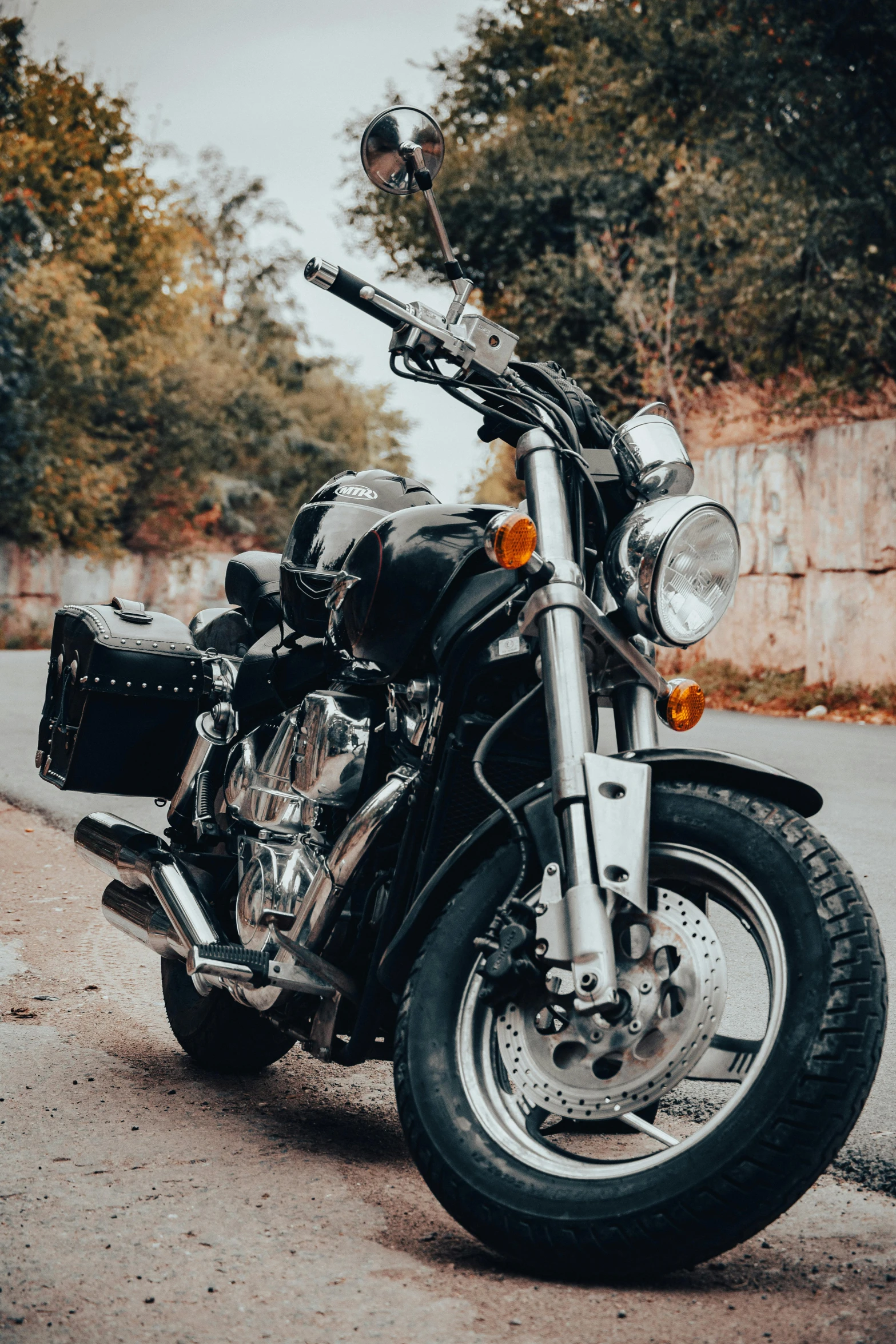 a motor cycle parked next to a gravel road