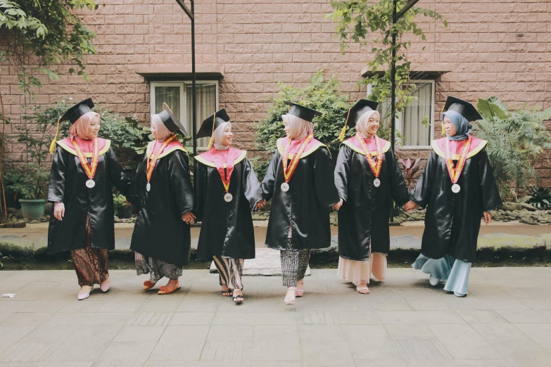 several young people are standing in a group in their graduation gowns