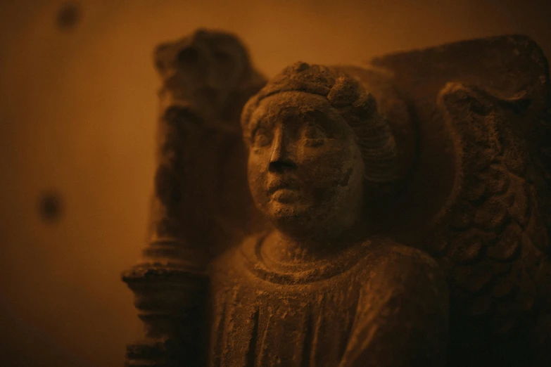 a statue sitting in front of a wooden pillar