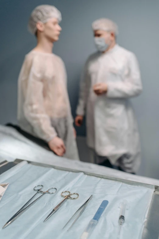 two people in masks standing next to medical equipment