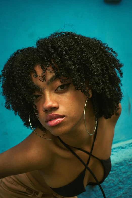 a woman with a messy curly afro looks on