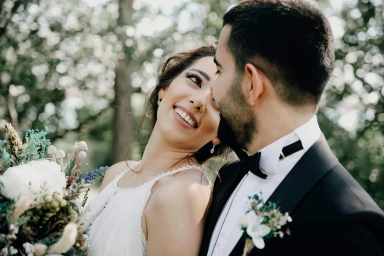 the bride and groom are standing close together