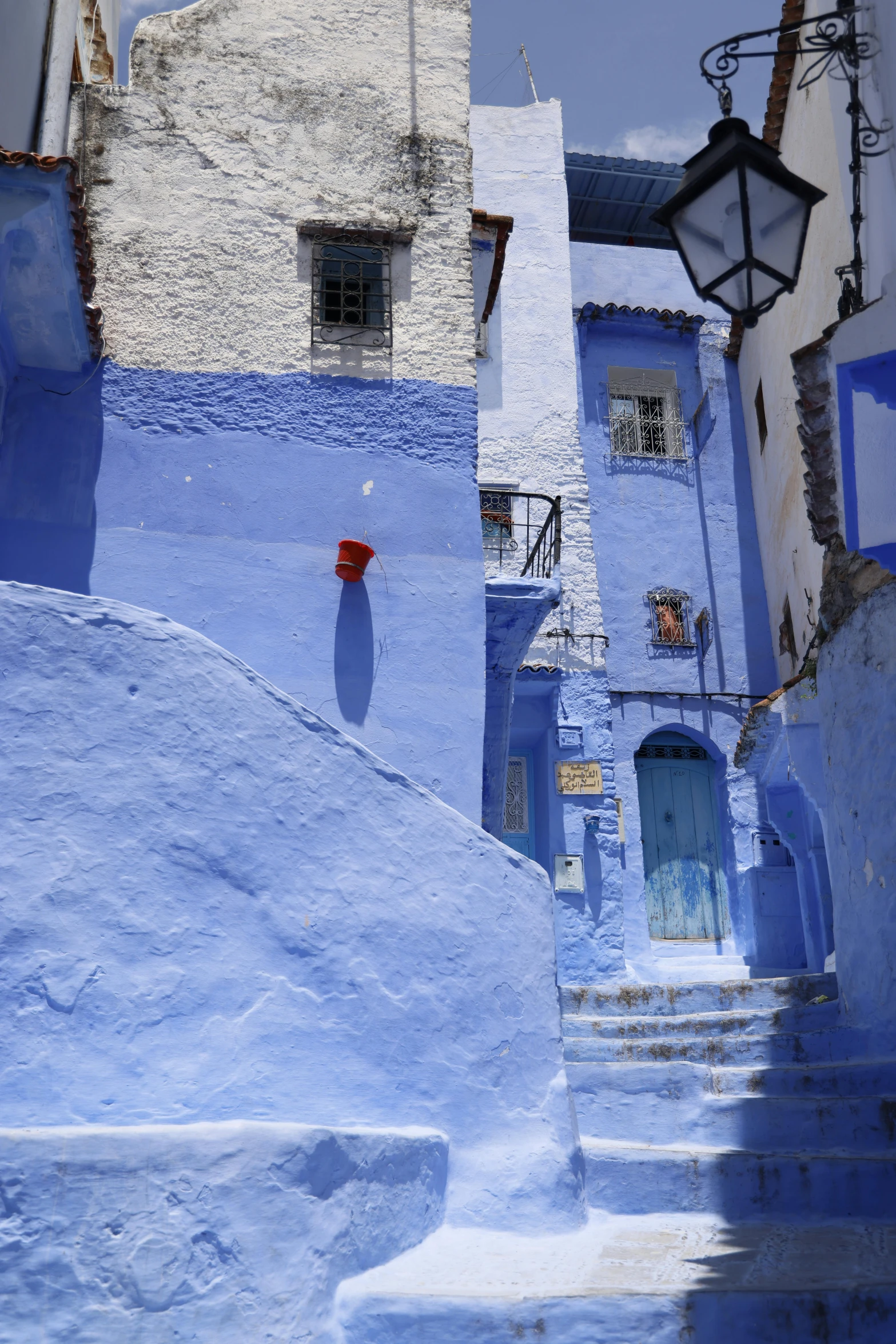 a blue street with steps leading to a building