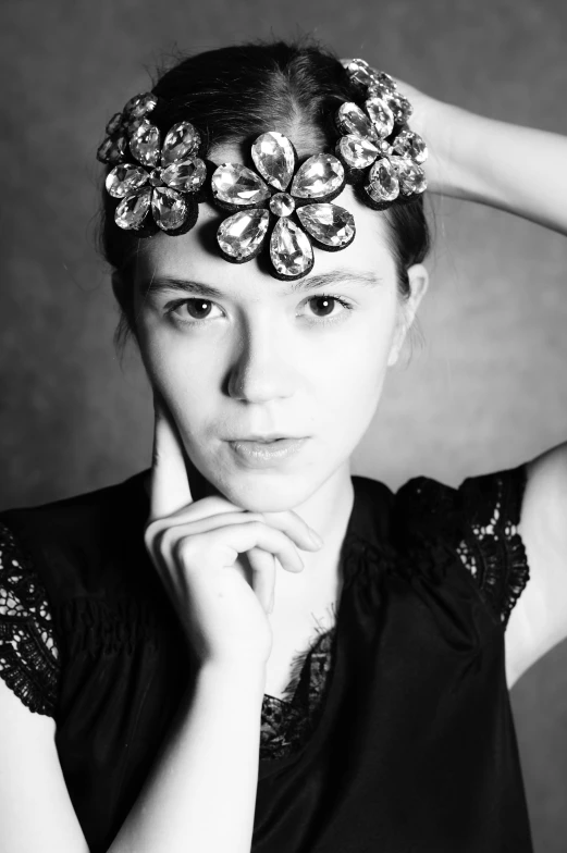 a woman is posing wearing a flowered hair piece