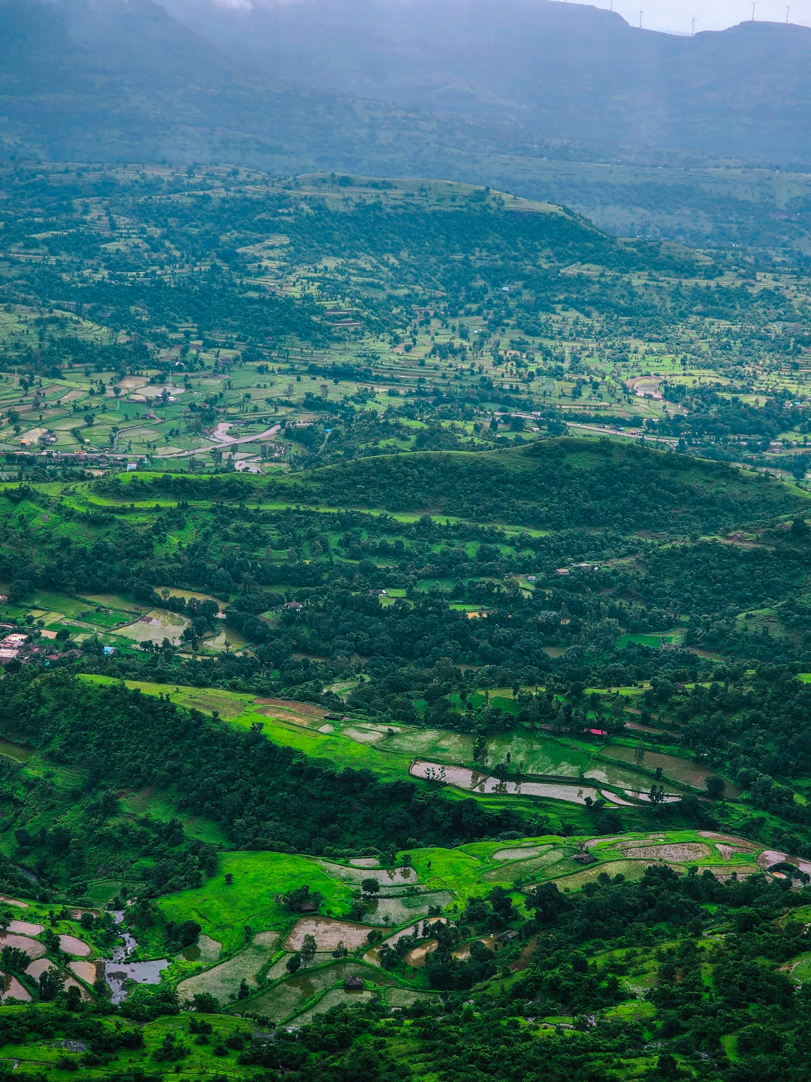 an aerial view of a town nestled between green mountains