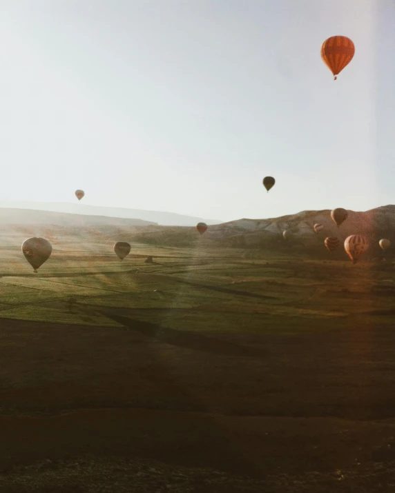 an image of balloons flying over the mountains