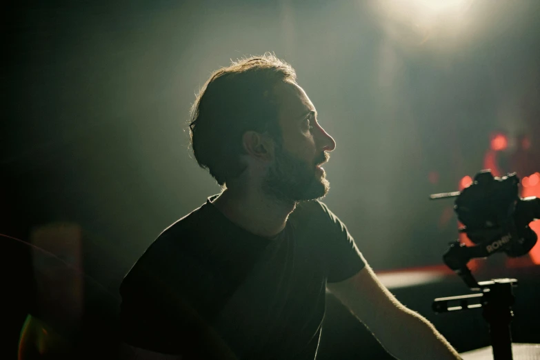 a man sitting at a piano in the dark