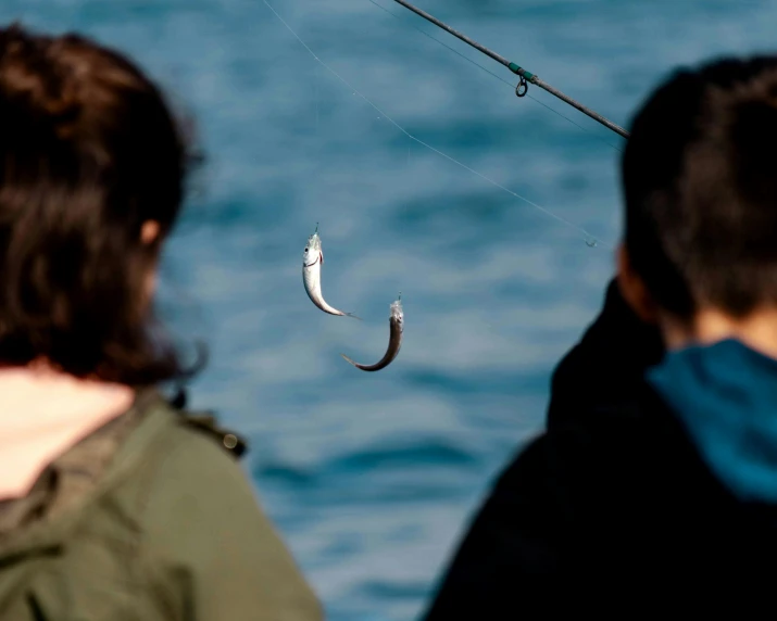 two people in the water watching a kite that is being flown