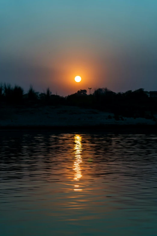 the sun is setting in the horizon as seen from a boat