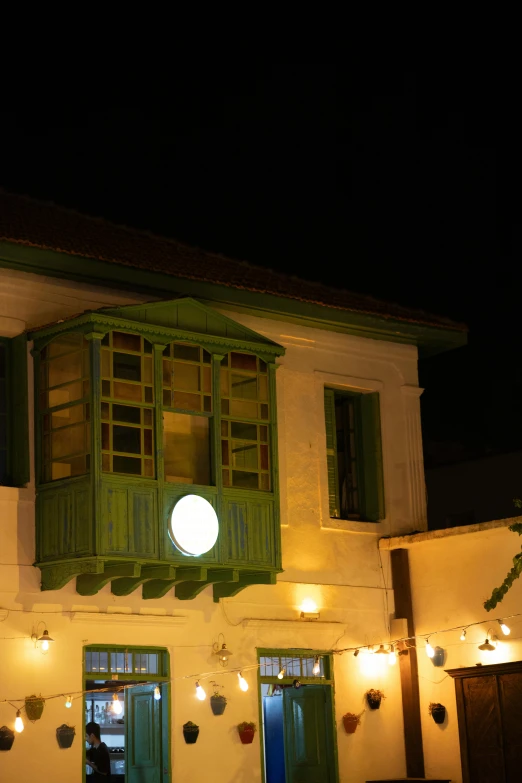 green wooden doors on the side of a white building