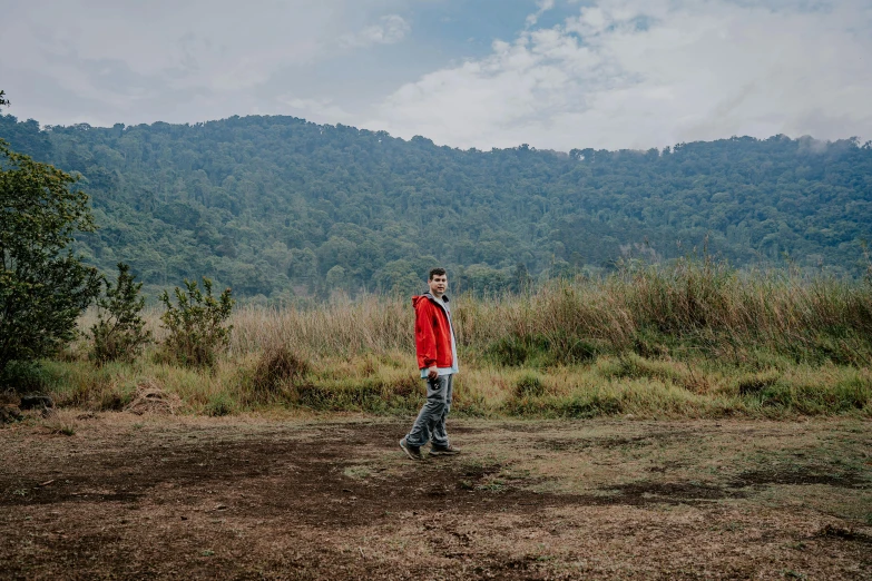 the man in the red jacket is walking along