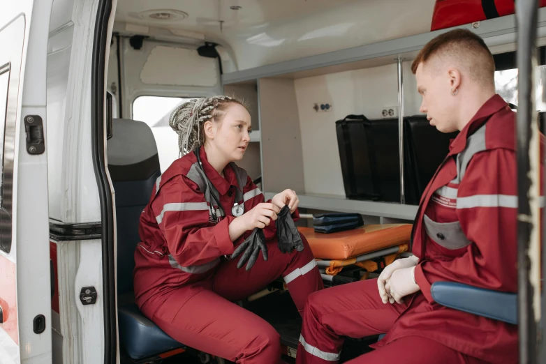 a woman in red sits next to a man in red safety attire