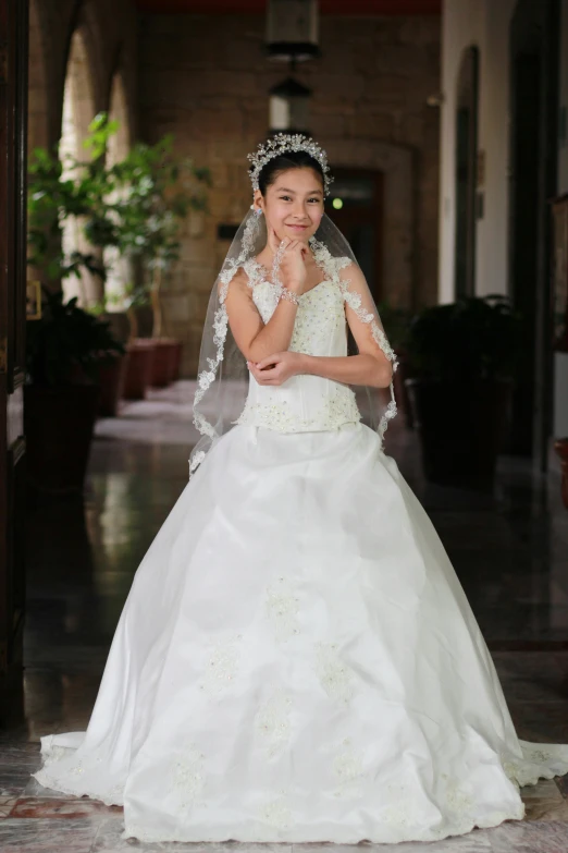 a young bride dressed in a ball gown, is posing for the camera