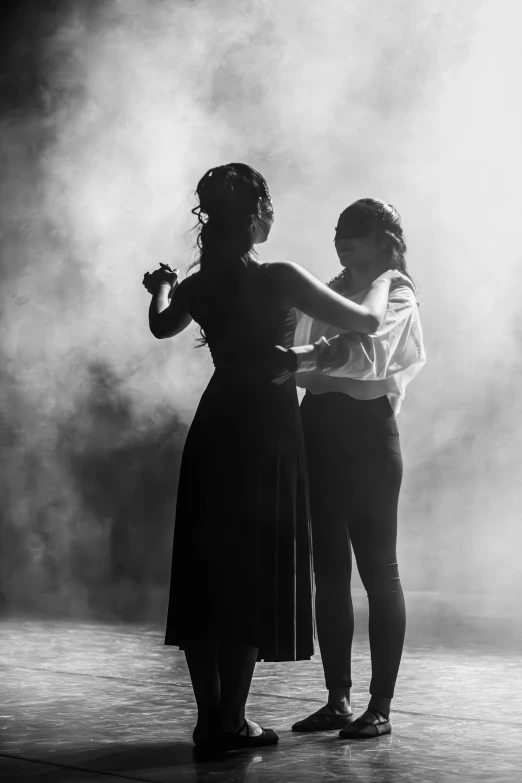 the two women are dancing together in an artistic dance performance