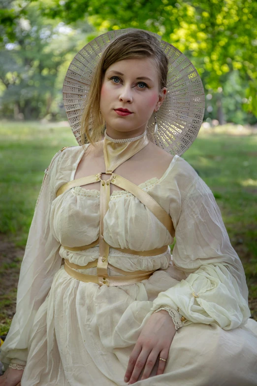 a women wearing a white dress and veil sits on the ground