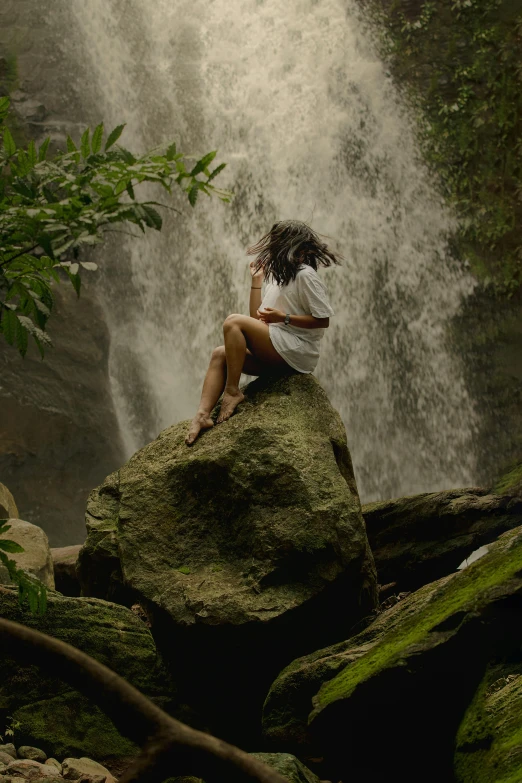 a person sitting on top of a large waterfall