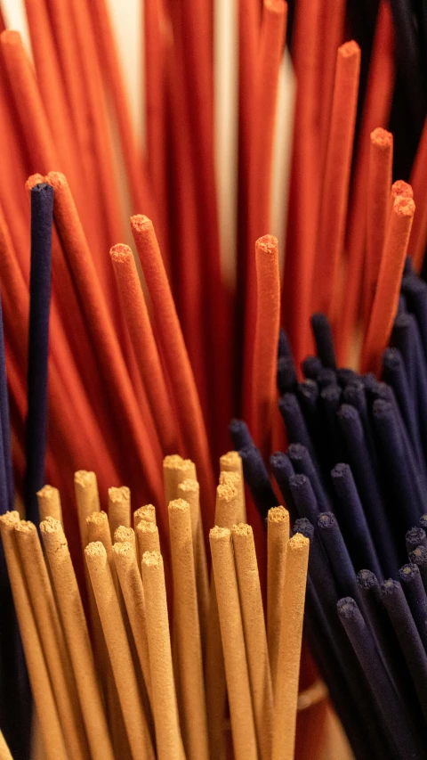 many brown, orange and blue straws are grouped together