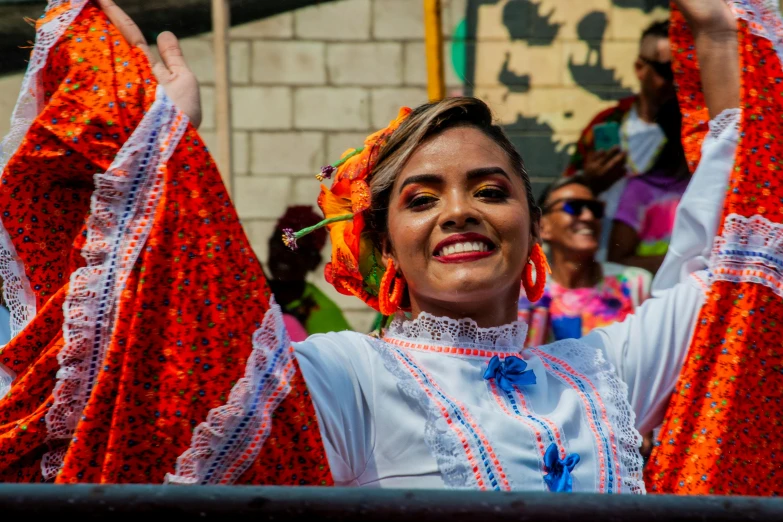 a woman wearing orange and blue attire dancing around