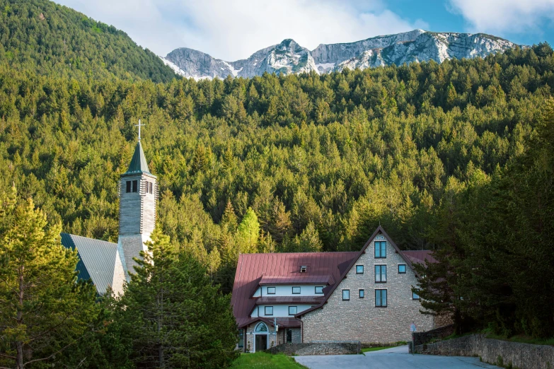 a white and blue building with a steeple surrounded by trees