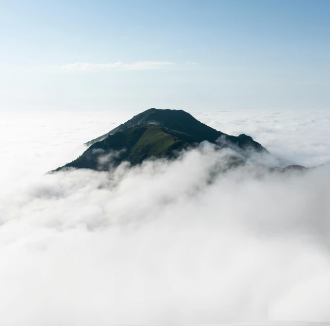 an island rising above the fog in the sky