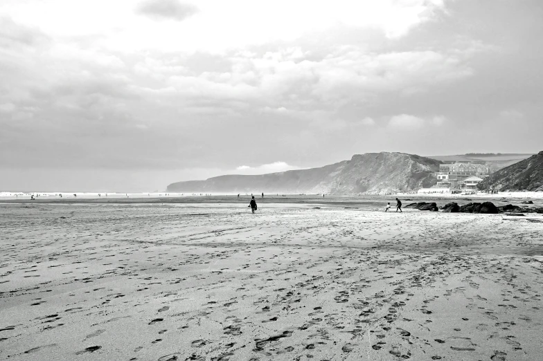 a couple of people walking along the beach