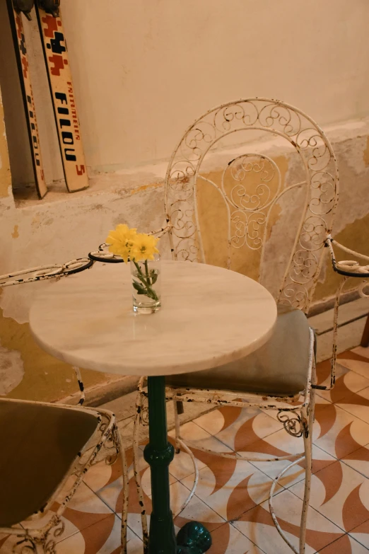 some chairs and a table with a yellow flower