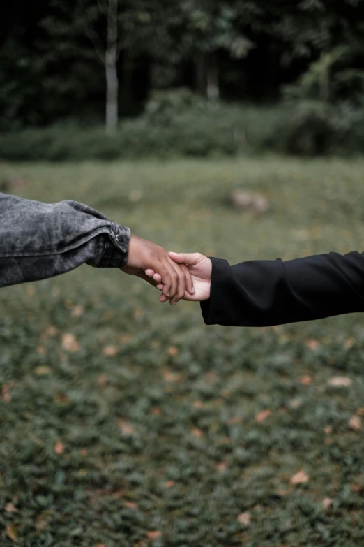 one person holding another persons hands outside