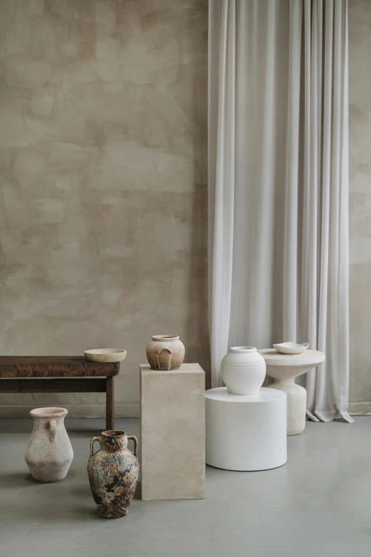 a table with vases in front of two white tables