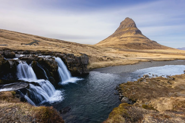 the beautiful waterfall is shown in front of the mountain