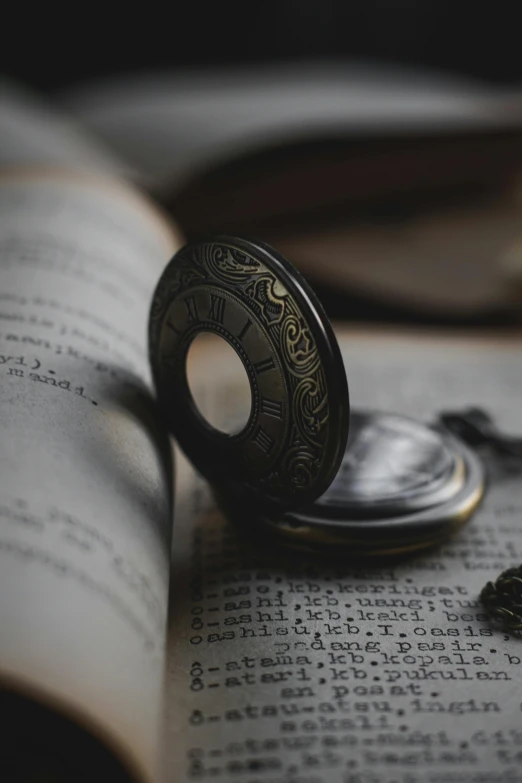 a pocket watch sitting on an open book