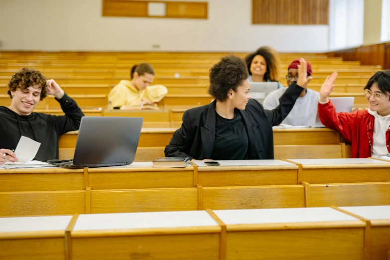 a group of students sitting on chairs with their laptops