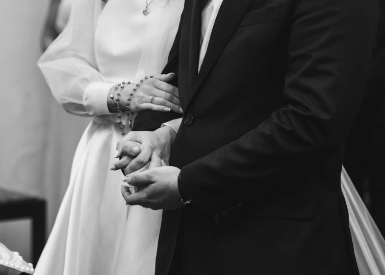 a woman and man standing next to each other holding hands