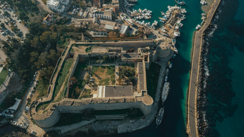 an aerial po of the castle near a marina