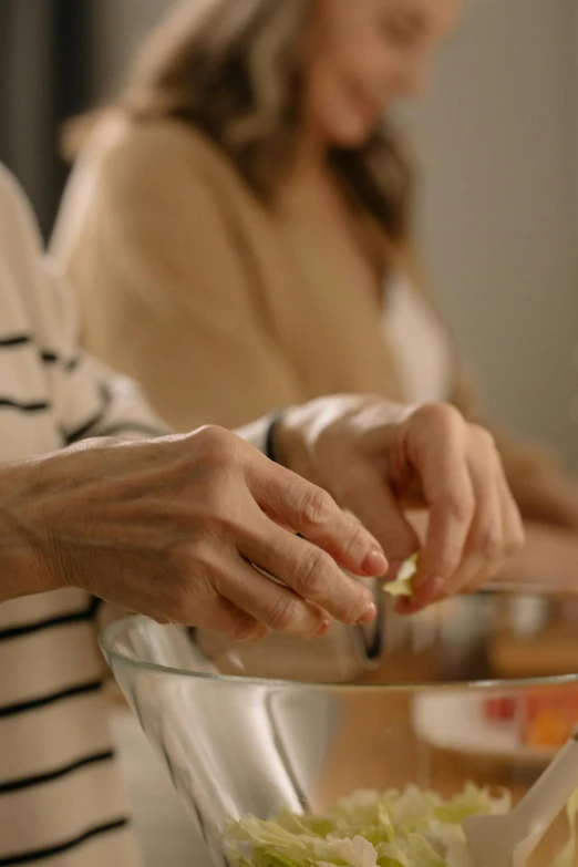 a woman putting some sort of food in a bowl