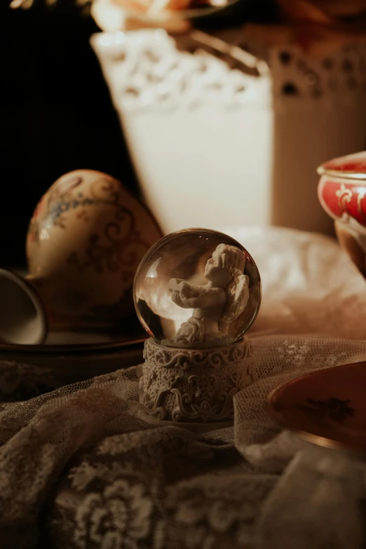 a decorative glass ball sits on a table next to other objects