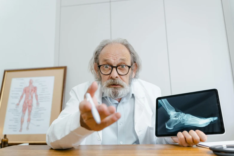 an old man pointing at an x - ray showing it's skeleton