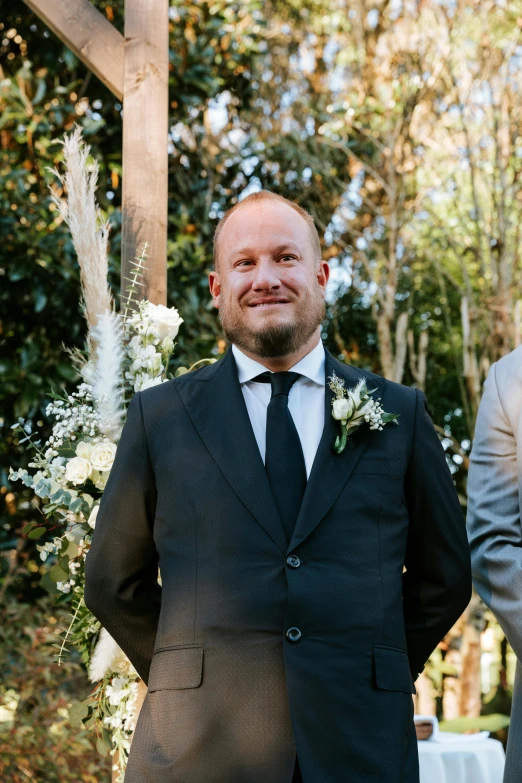 man in black suit and tie with black white flowers