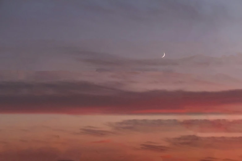 the sky has some clouds and a very bright moon